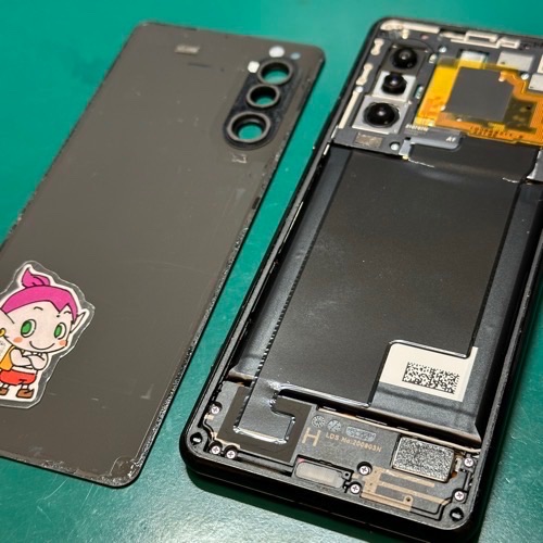 Xperia 5 IIの背面パネルを温めて慎重に取り外している様子。